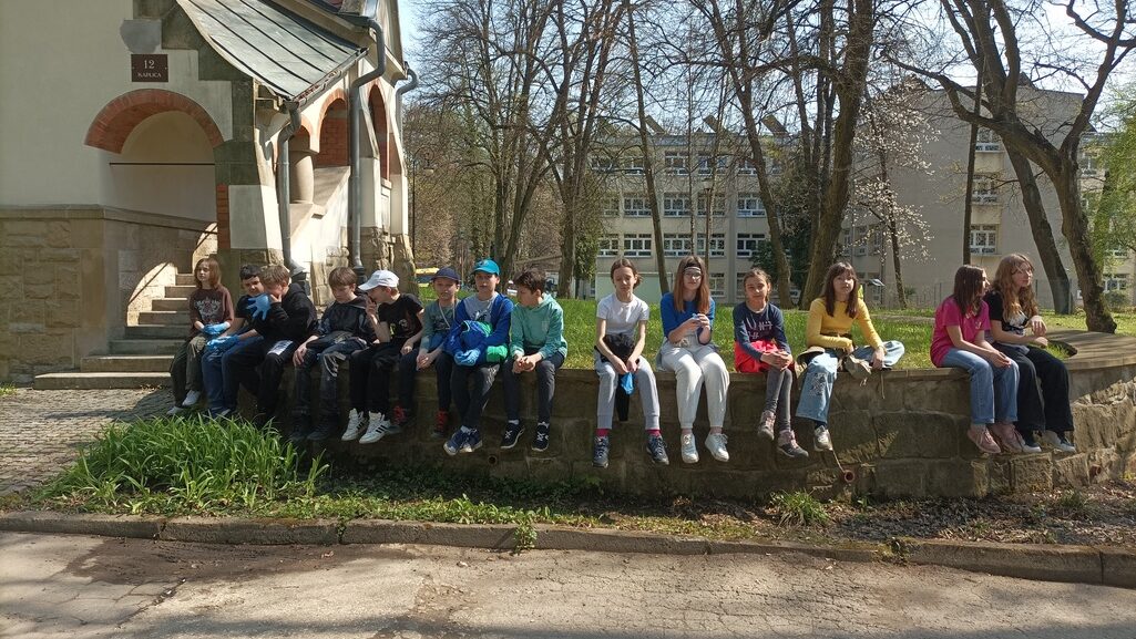 Grupa dzieci siedzących na murku